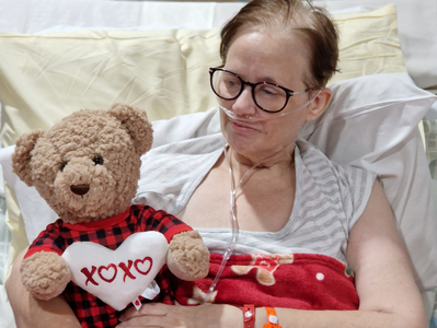 Ben's mum in hospital bed holding a Christmas teddy