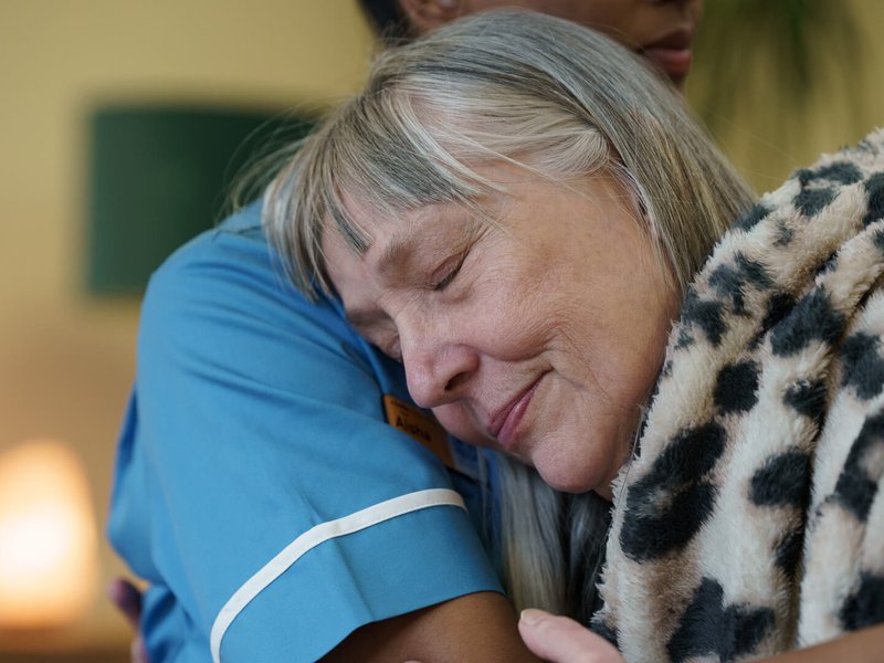 A Sue Ryder Nurse hugging a patient in a hospice