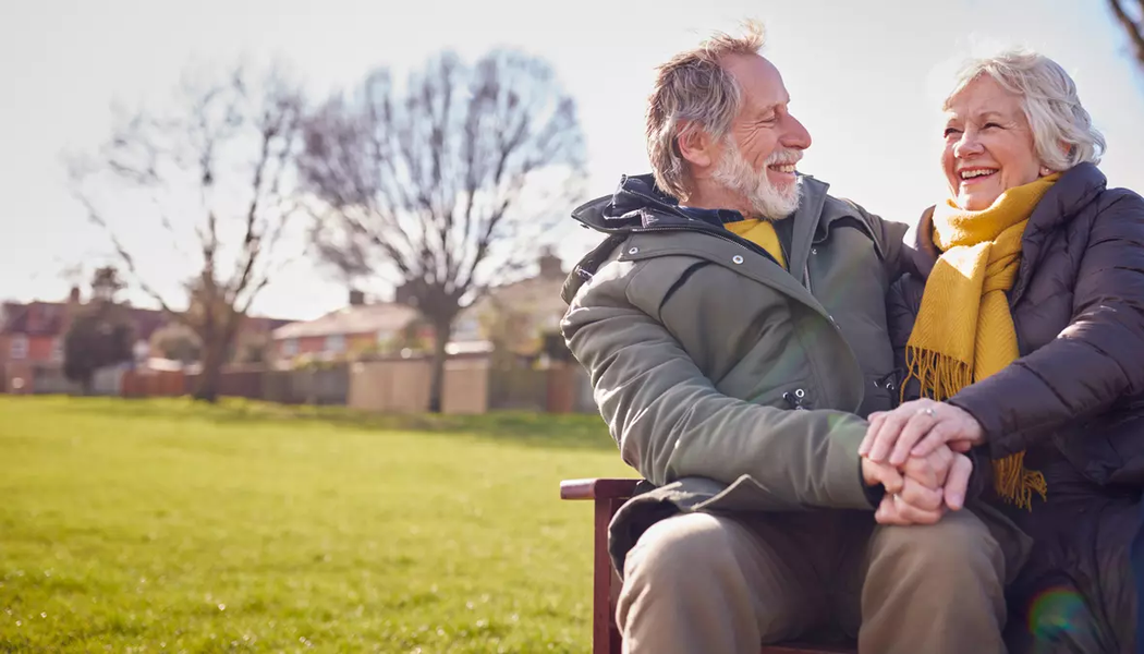 Photo of an older couple holding each other and smiling