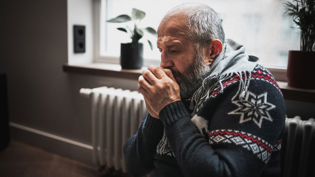 Image representing Safe and Warm SGN Sue Ryder partnership, man in a winter jumper warming up his hands