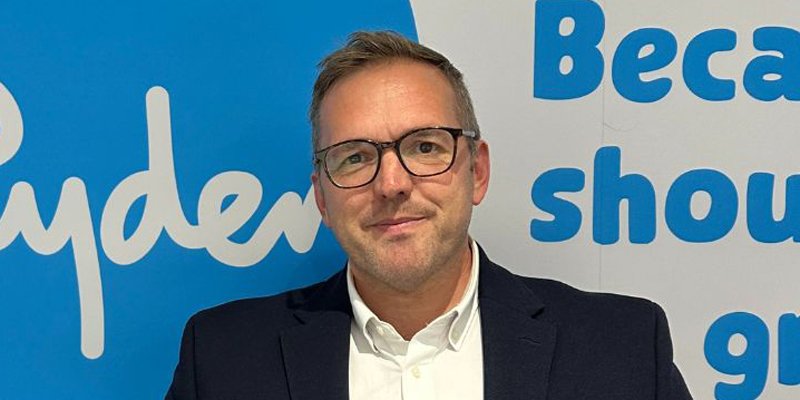Sue Ryder CEO, James Sanderson, in front of a Sue Ryder sign