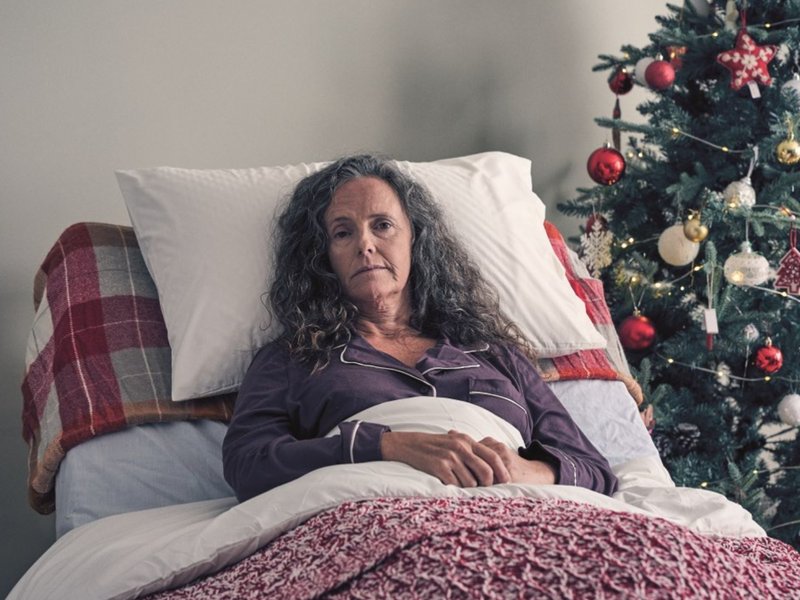 Sue Ryder Patient in bed next to a Christmas Tree