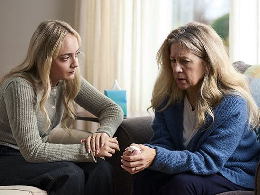 A daughter talks to her mother in their living room after a bereavement