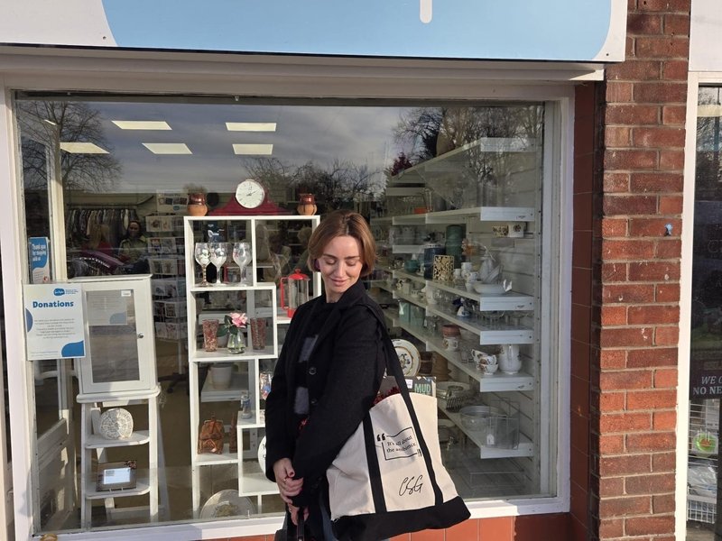 Jennifer Graham aka Charity Shop Girl stood outside of a Sue Ryder shop with the exclusive tote bag on her shoulder
