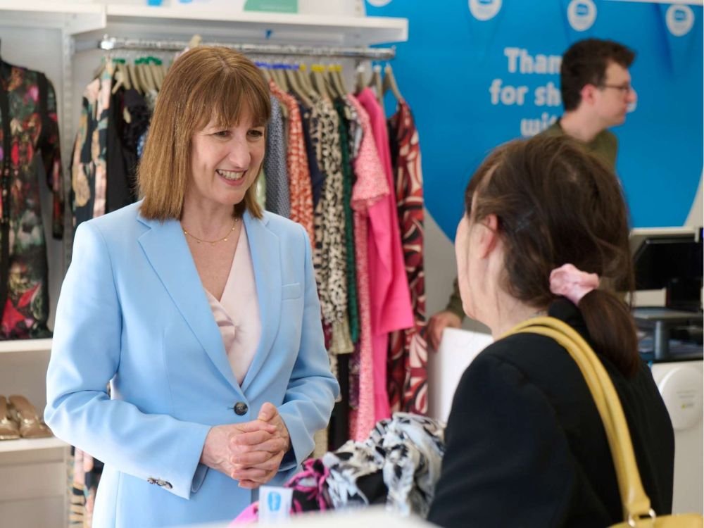 Rachel Reeves in a blue jacket speaks with another woman in a Sue Ryder shop