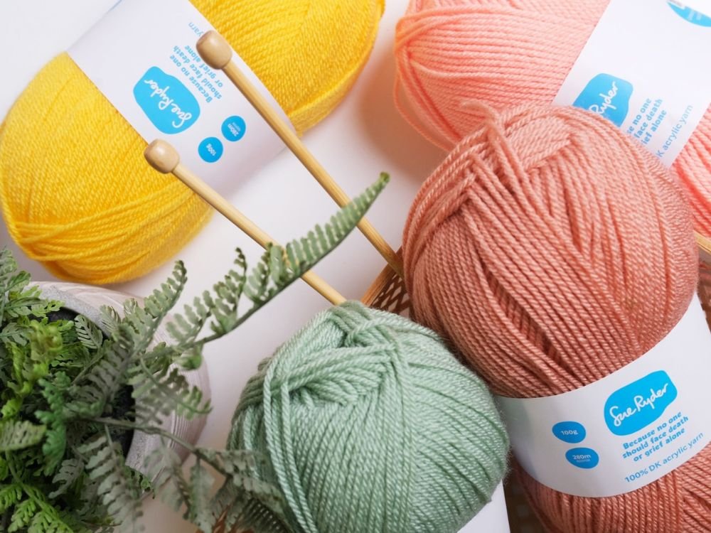 Colorful yarn balls and knitting needles arranged together, showcasing a variety of textures and hues.