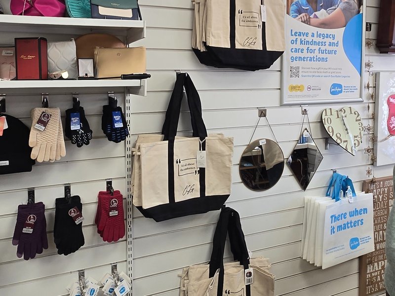 Image of Charity Shop Girl x Sue Ryder tote bags in a Sue Ryder shop