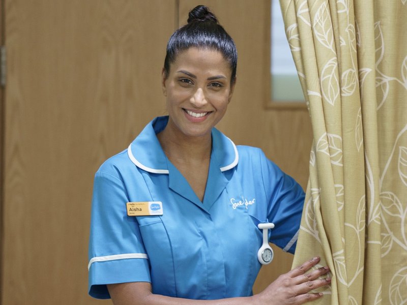 Image of a female Sue Ryder Nurse wearing a blue uniform on a Sue Ryder hospice ward