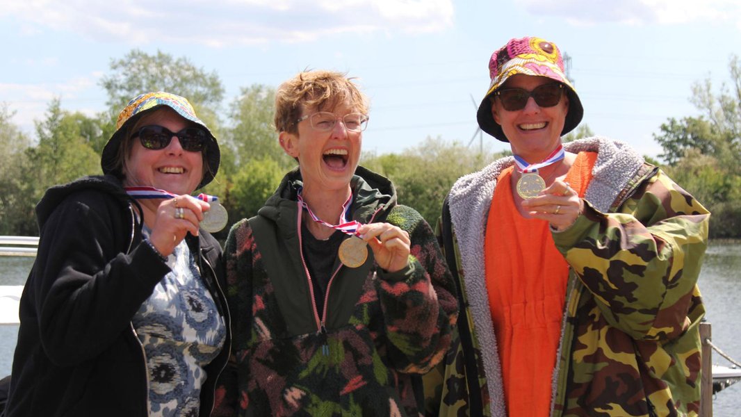 Three Lap the Lake swimmers celebrating with their medals
