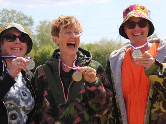 Three Lap the Lake swimmers celebrating with their medals